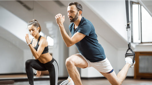 Two individuals are seen in a gym, smiling and engaged in their workout routine. They radiate positivity and determination, embodying the joy and satisfaction found in physical activity and wellness.