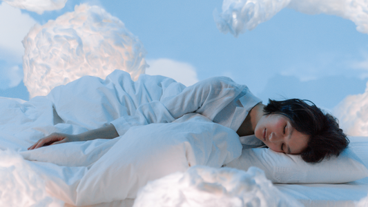 Image of a young woman asleep amidst soft, blue clouds, evoking a dreamlike and peaceful atmosphere. This serene visual metaphorically represents the calming and sleep-inducing effects of the 'Twilight' supplement from Peach Perfect.